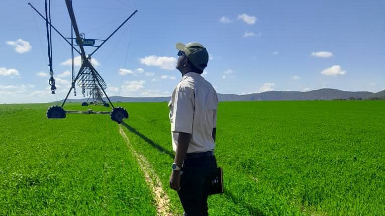 Field worker inspecting a centre-pivot irrigation system